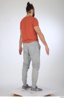 Turgen casual dressed grey sneakers grey trousers orange t-shirt standing…